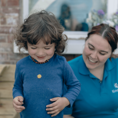 An adult and child are playing and smiling outside