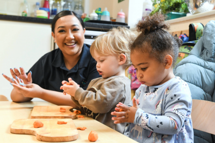 An adult and toddlers are playing with playdough