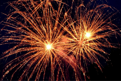 A photo of orange fireworks against the night sky