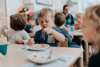 a boy eats spaghetti at nursery