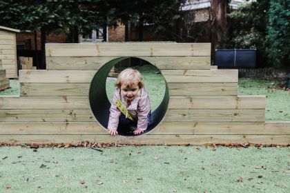 Child playing outside in Kindred Bromley North's large outdoor garden
